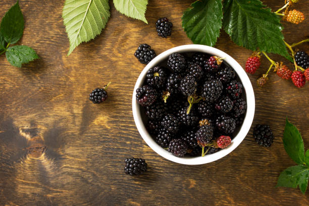 istock Berries ripe blackberries on kitchen wooden table. Top view flat lay background, copy space. 1141270220