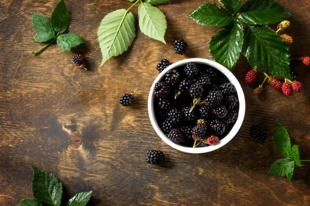 istock Berries ripe blackberries on kitchen wooden table. Top view flat lay background, copy space. 1141270222
