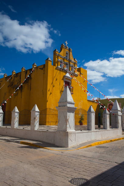 Campeche, Mexico - January 31,2018: Yellow colonial church with a deep blue sky .The city is known for its beautiful preserved colonial buildings, many of which are painted in bright shades of blue, pink, yellow, and green.