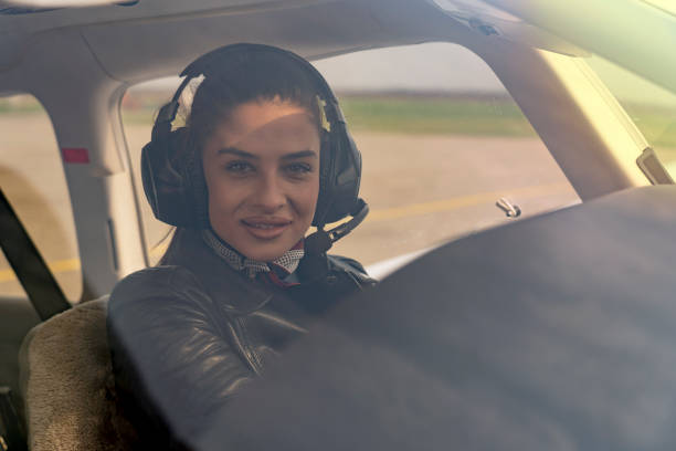 istock Beautiful Young Woman Pilot With Headset Looking Through The Cockpit Window 1141276134