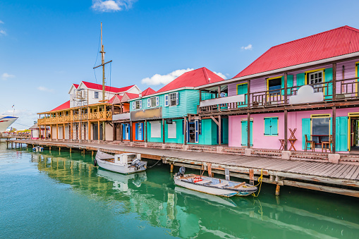 Bright image with colorful houses and shops along the waterfront at the port of St John`s, Antigua and Barbuda, Caribbean. Popular cruise destination.
