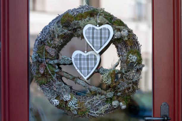 guirnalda de navidad hecha de plantas naturales de hoja perenne y decorada con pequeños arcos de yute en la puerta - piny fotografías e imágenes de stock