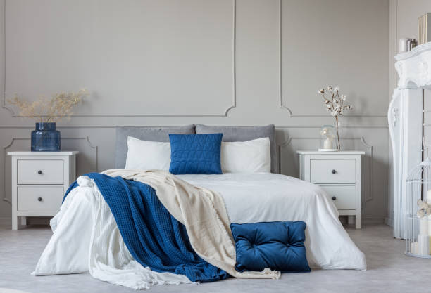 istock Grey, white and blue pillows and blanket on king size bed in elegant bedroom with copy space 1141278039