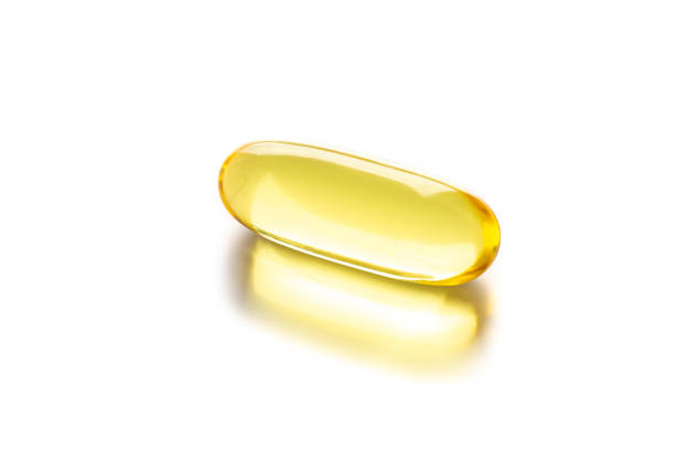 close up of food supplement oil filled softgel/capsules suitable for fish oil, omega 3-6-7-9 on white background. concept healthy lifestyle - 3679 imagens e fotografias de stock