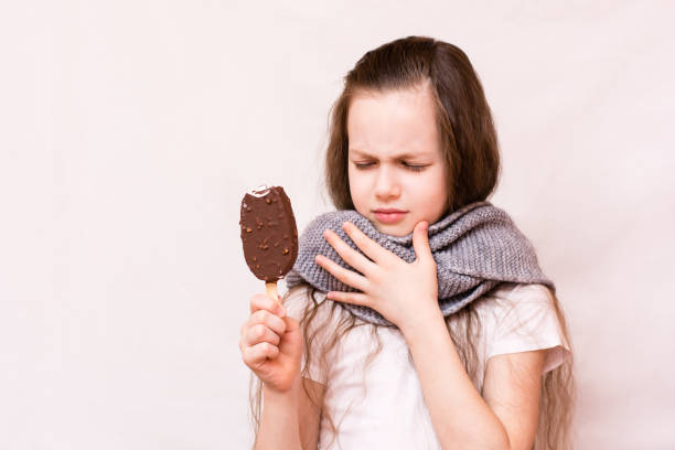 the girl bit off the ice cream and her throat ached - affraid imagens e fotografias de stock
