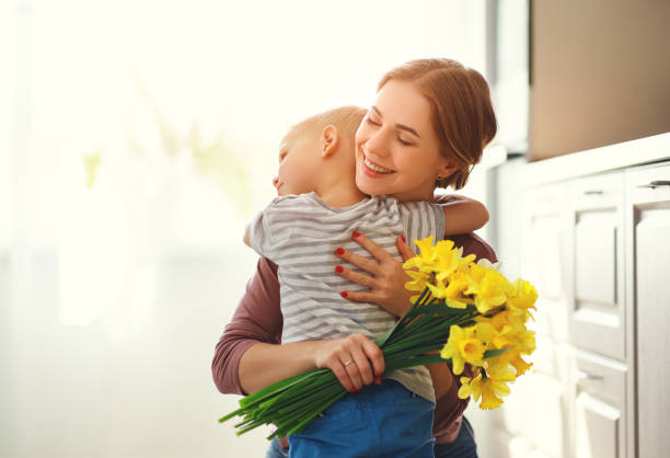 happy mother's day! child son gives flowersfor  mother on holiday - daffodil flower yellow plant imagens e fotografias de stock