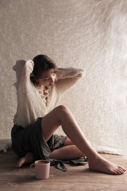 istock Young Women sitting wooden floor 1141287111