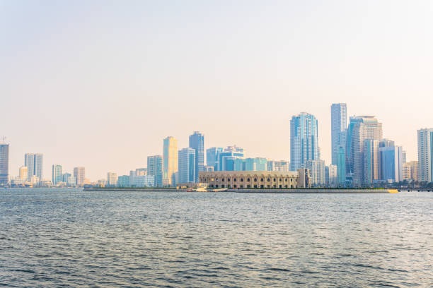 vista panoramica della laguna di khalid, tra cui l'anfiteatro di al majaz circondato da un grattacielo nell'emirato sharjah, emirati arabi uniti - skyscraper city life urban scene building exterior foto e immagini stock