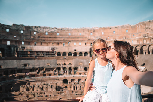 Family in Coliseum in Rome, Italy. Mother and little happy girl at famous place in Europe