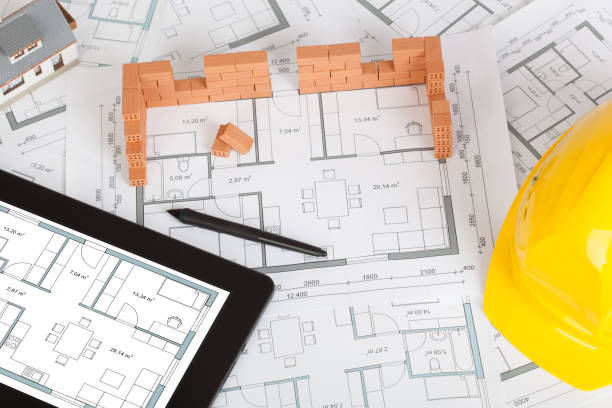 istock Model house construction with brick on blueprint, helmet and tablet 1141290775