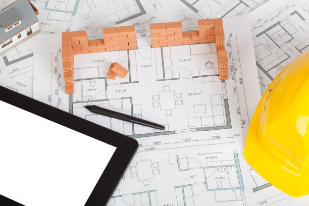 istock Model house construction with brick on blueprint, helmet and tablet 1141290797