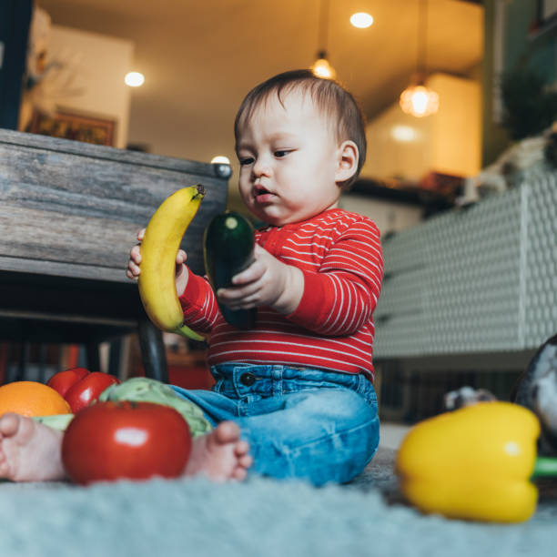 istock Baby boy playing with fresh fruit and vegetables 1141292484