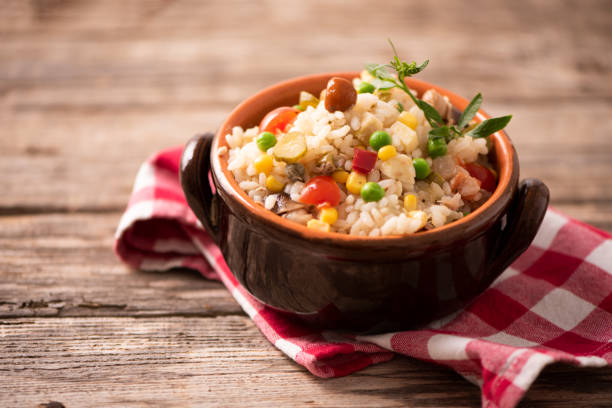 Rice salad in a bowl on wooded table stock photo