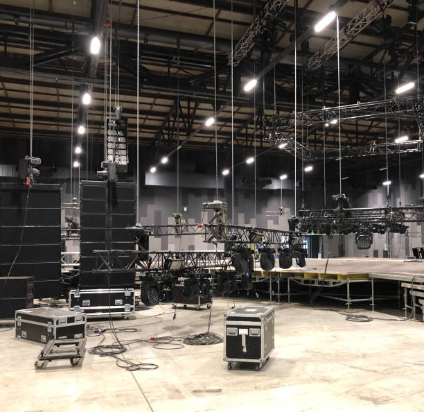 instalación de equipo profesional de sonido, luz, vídeo y escenario para un concierto. levantamiento de cercha y maletas de vuelo con cables. - industrial equipment audio fotografías e imágenes de stock