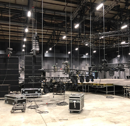 Installation of professional sound, light, video and stage equipment for a concert. Lifting truss and flight cases with cables.