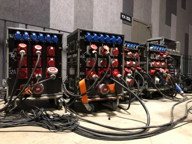 Photo of Electric power distribution boxes with power and signal cables. Installation of professional equipment for a concert.