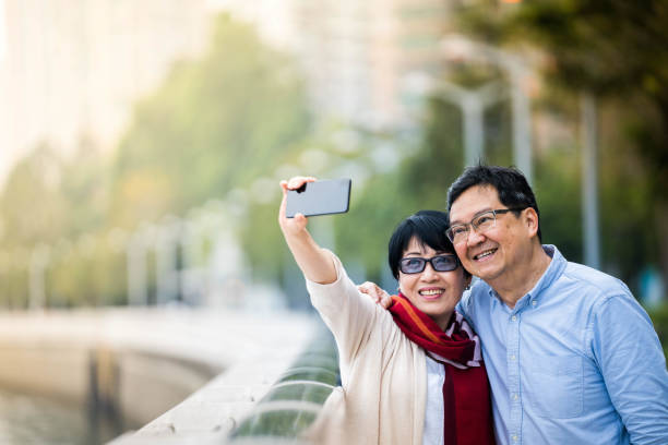 istock Asian senior couple taking using mobile phone 1141293724