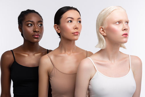 Tres mujeres con diferentes colores de piel que llevan camisolas photo