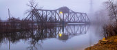 istock Eerie old railroad trestle bridge in foggy twilight. 1141294493