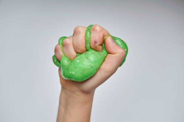 istock Hand squeezing green slime. Isolated on white background. 1141297234