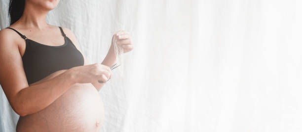 istock Pregnant woman cutting a condom 1141297383