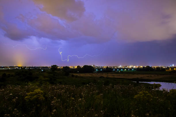 Intracloud lightning thunderbolt IC strikes at night above a city.