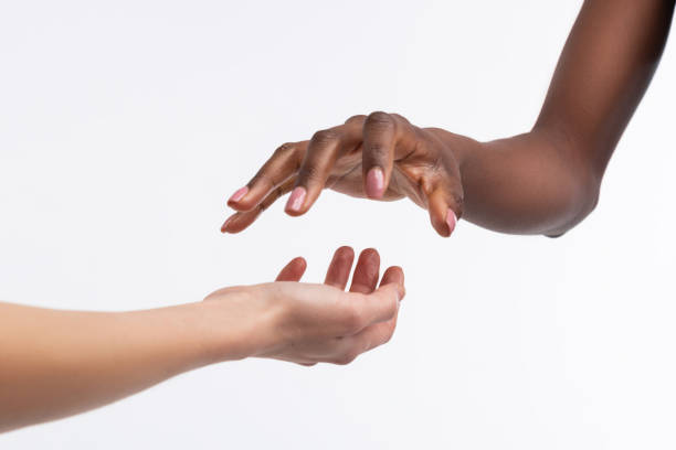 istock Dark-skinned woman holding her hand above white hand 1141299421