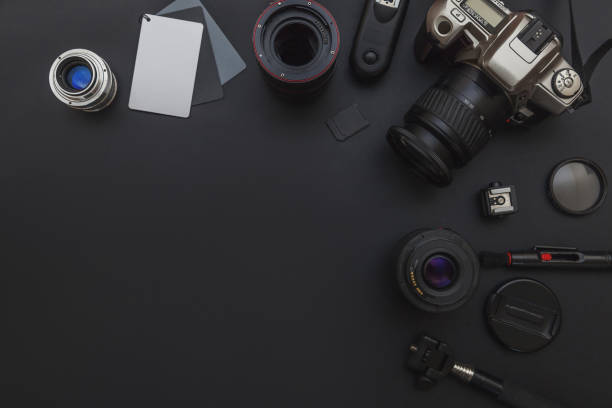 istock Photographer workplace with dslr camera system, camera cleaning kit, lens and camera accessory on dark black table background 1141302431