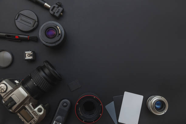 istock Photographer workplace with dslr camera system, camera cleaning kit, lens and camera accessory on dark black table background 1141302442