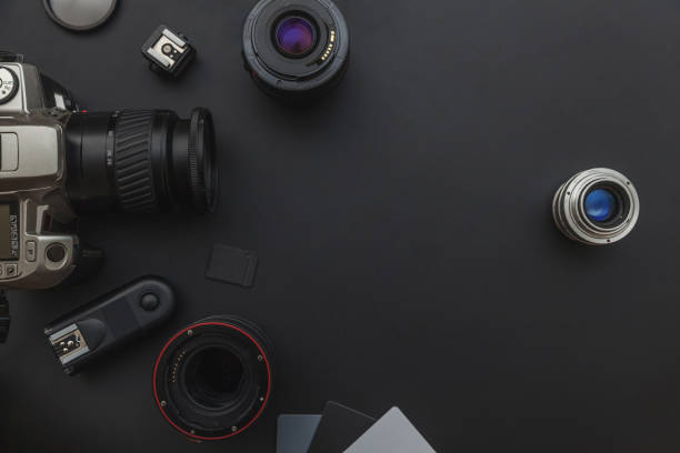 istock Photographer workplace with dslr camera system, camera cleaning kit, lens and camera accessory on dark black table background 1141302451