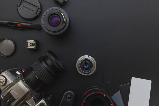 istock Photographer workplace with dslr camera system, camera cleaning kit, lens and camera accessory on dark black table background 1141302461