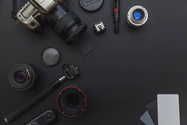 istock Photographer workplace with dslr camera system, camera cleaning kit, lens and camera accessory on dark black table background 1141302468