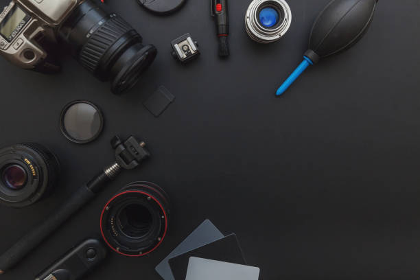 istock Photographer workplace with dslr camera system, camera cleaning kit, lens and camera accessory on dark black table background 1141302507