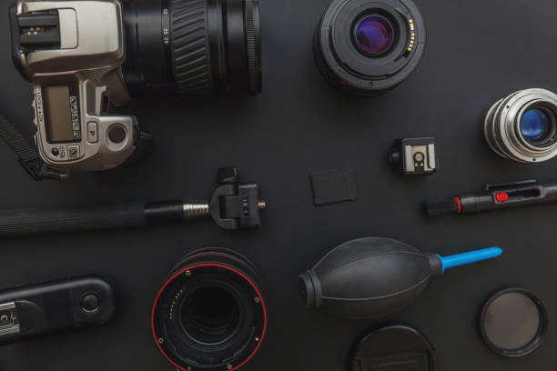 istock Photographer workplace with dslr camera system, camera cleaning kit, lens and camera accessory on dark black table background 1141302527
