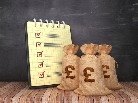 Check List Note Pad with Pound Money Sacks on Chalkboard Background  - 3D Rendering