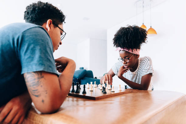 istock Two teenagers playing chess at home 1141303870