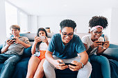 Group of young friends playing mobile games on smartphone