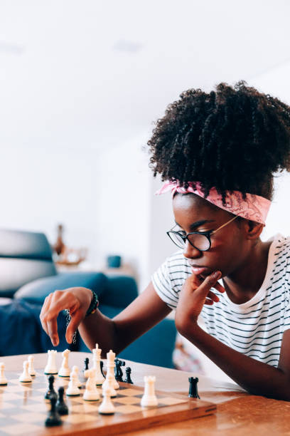 istock Young afro descendant teenager playing chess 1141305028