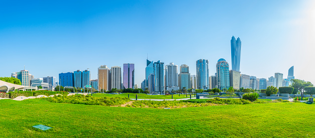 View of a corniche in Abu Dhabi stretching alongside the business center full of high skyscrapers.