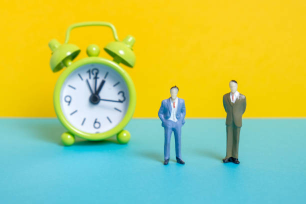 istock Men dummy next to a green vintage clock on a yellow background. 1141306570