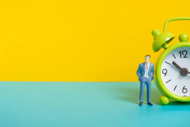 istock Man's dummy next to a green vintage clock on a yellow background and right side. 1141306597