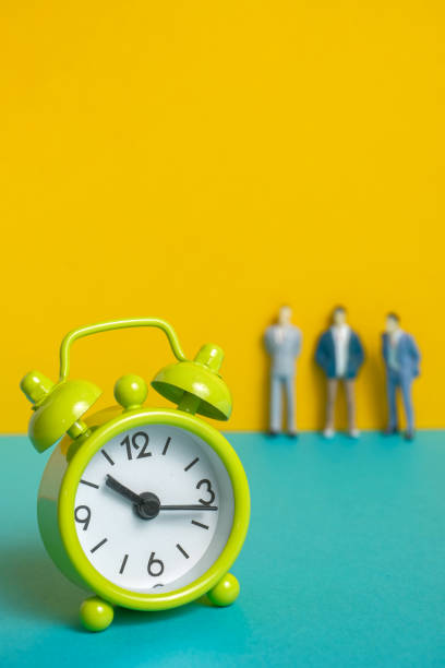 istock Man's dummy next to a green vintage clock on a yellow background. 1141306656