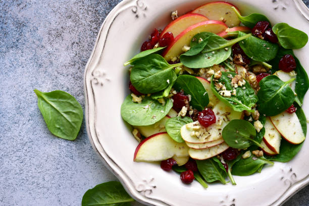 Vegan spinach salad with apple, dried cranberry and walnut