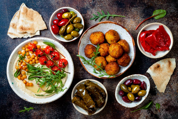 hummus fatto in casa con pomodorini arrostiti e pane pita. cucina araba tradizionale e autentica mediorientale. vista dall'alto, lay piatto, sopra la testa - greek cuisine greek culture food table foto e immagini stock