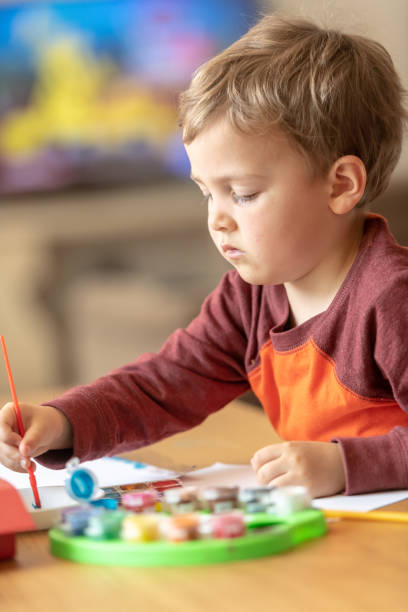 istock Three years old child painting with watercolors 1141312705