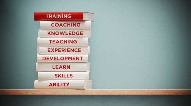 books of  training and development in front grey wall - success practicing book stack imagens e fotografias de stock