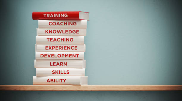 Books of training, development and skills are sitting on top of each other. The books have unique texts on their spines related to training subject.
