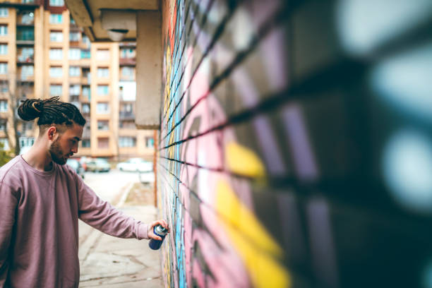 graffiti-künstler mit dreadlocks - straßenmaler stock-fotos und bilder