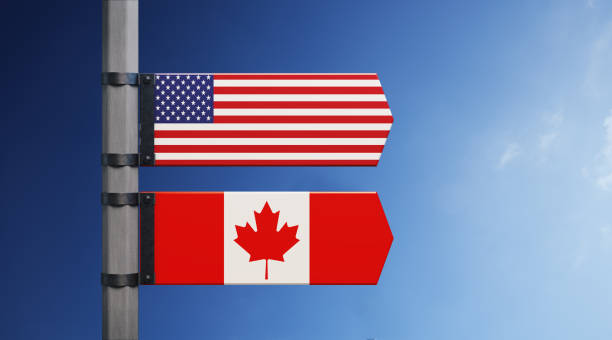 american and canadian flag pair on road sign - canada american flag canadian culture usa stock-fotos und bilder
