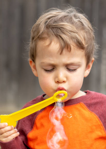 трехлетний мальчик дует пузыри - 2 3 years toddler bubble wand child стоковые фото и изображения